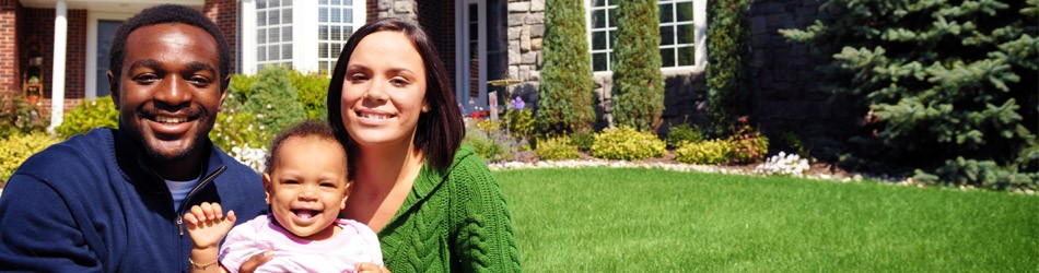Family sitting in front of a house