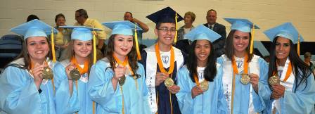 A group of Truman Honors Students in caps and gowns holding up diplomas 