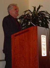 Sam Pizzo speaking at a podium.