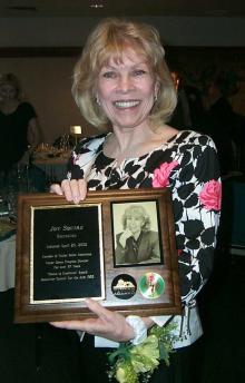 Joy Squire holding a plaque.