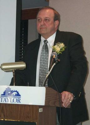 Gene Stus speaking at a podium.