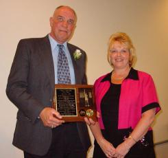 Fred Thomann and woman holding a plaque.