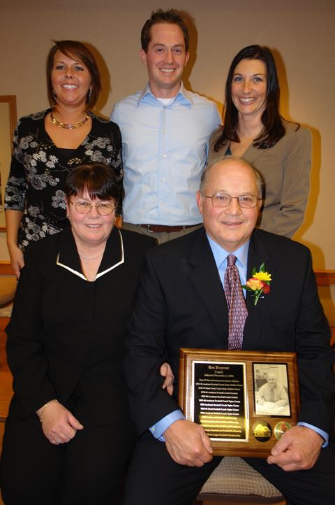 A group of people standing with a man holding a plaque.