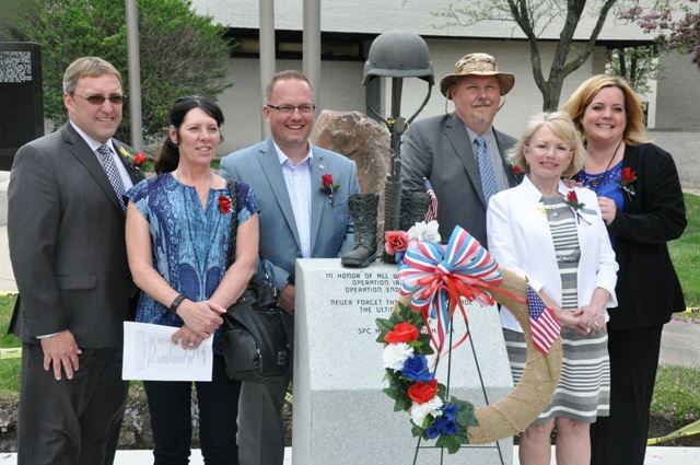 Elected officials around a statue for Holly McGeogh at her memorial.