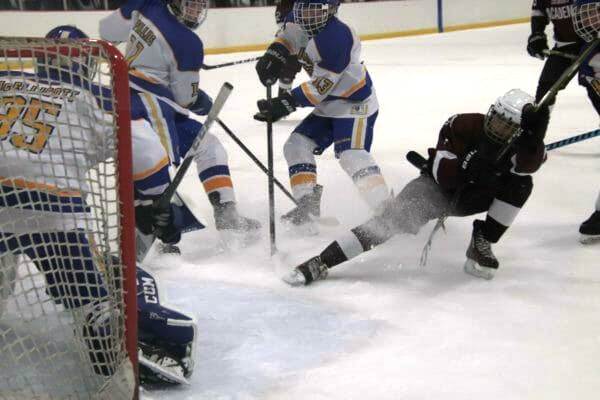Image of a hockey player sliding on the ice. 